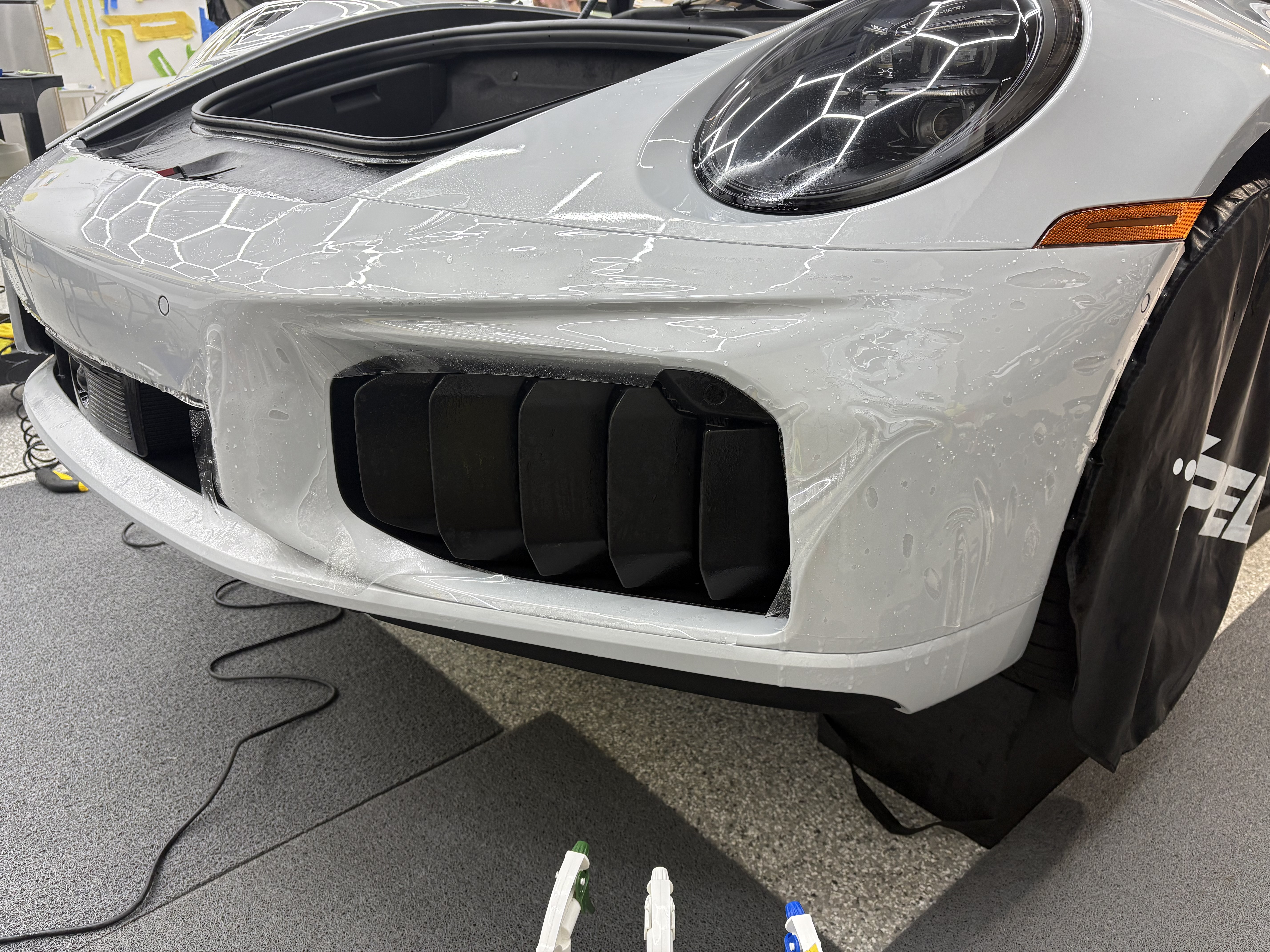 XPEL paint protection film installation on a white Porsche front bumper in Atlanta Georgia